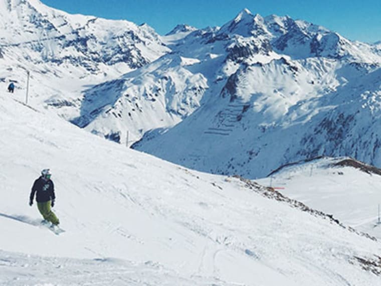Snow-covered alpine mountain peaks under a bright sky.